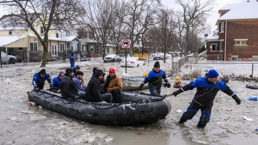 Sebuah truk pemuat depan melaju di Green Street setelah pipa air utama pecah di Detroit yang menyebabkan banjir besar dan memicu evakuasi, Senin, 17 Februari 2025. (Andy Morrison/Detroit News via AP)