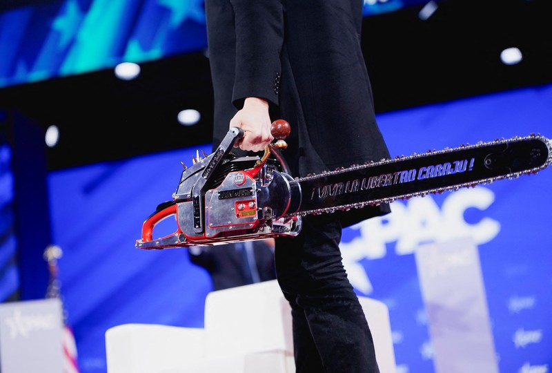 Elon Musk memegang gergaji mesin di atas panggung saat menghadiri Konferensi Aksi Politik Konservatif (CPAC) di National Harbor, Maryland, AS, 20 Februari 2025. (REUTERS/Nathan Howard)