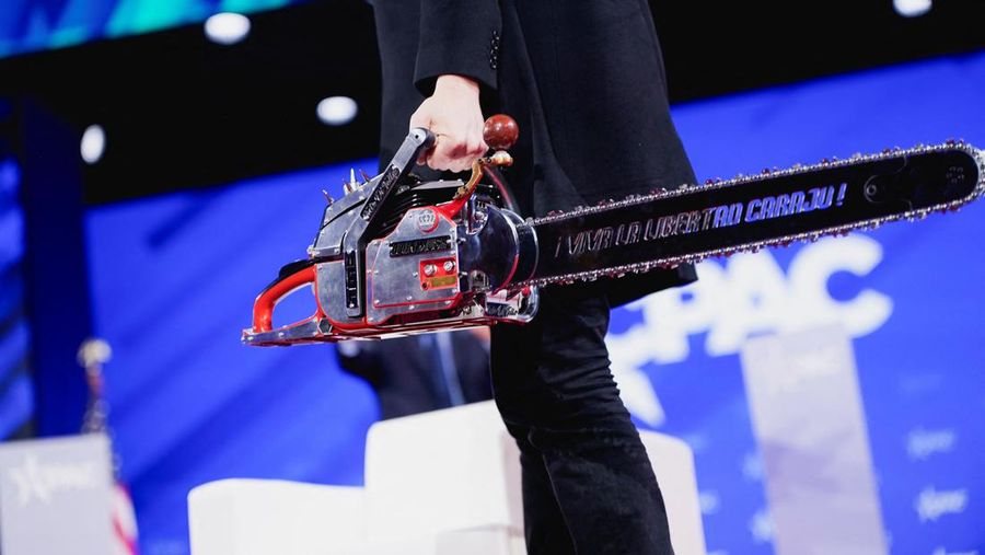 Elon Musk memegang gergaji mesin di atas panggung saat menghadiri Konferensi Aksi Politik Konservatif (CPAC) di National Harbor, Maryland, AS, 20 Februari 2025. (REUTERS/Nathan Howard)