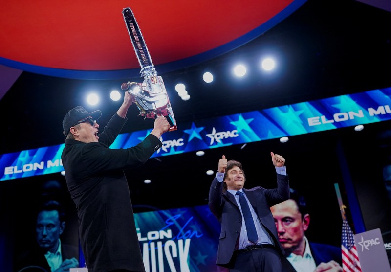 Elon Musk memegang gergaji mesin di atas panggung saat menghadiri Konferensi Aksi Politik Konservatif (CPAC) di National Harbor, Maryland, AS, 20 Februari 2025. (REUTERS/Nathan Howard)