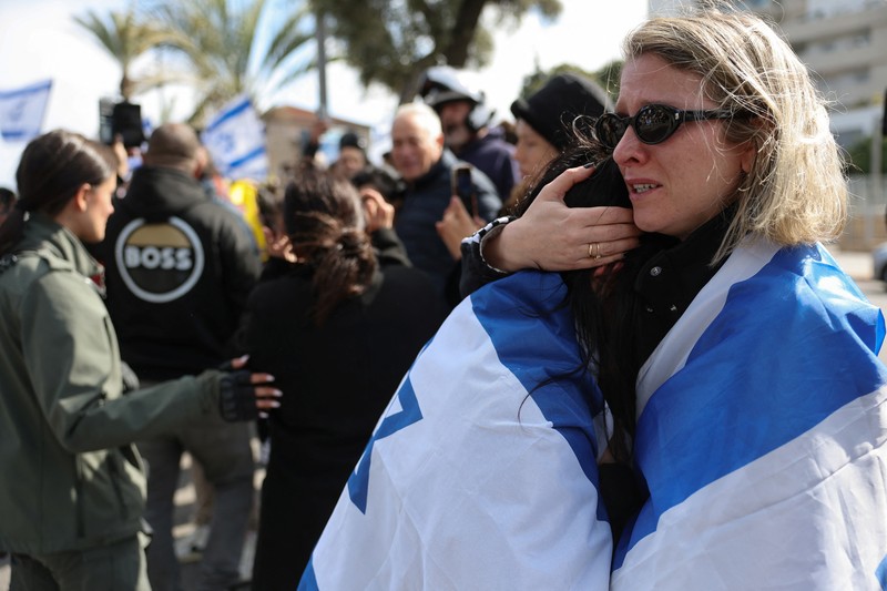 Warga Palestina menyaksikan penyerahan sandera yang telah meninggal, Oded Lifschitz, Shiri Bibas, dan kedua anaknya, Kfir dan Ariel Bibas, yang ditawan dalam serangan mematikan pada 7 Oktober 2023, oleh Hamas kepada Palang Merah sebagai bagian dari gencatan senjata dan kesepakatan pertukaran sandera-tahanan antara Hamas dan Israel, di Khan Younis di Jalur Gaza selatan, 20 Februari 2025. (REUTERS/Ramadan Abed) Warga Palestina menyaksikan penyerahan sandera yang telah meninggal, Oded Lifschitz, Shiri Bibas, dan kedua anaknya, Kfir dan Ariel Bibas, yang ditawan dalam serangan mematikan pada 7 Oktober 2023, oleh Hamas kepada Palang Merah sebagai bagian dari gencatan senjata dan kesepakatan pertukaran sandera-tahanan antara Hamas dan Israel, di Khan Younis di Jalur Gaza selatan, 20 Februari 2025. (REUTERS/Ramadan Abed)