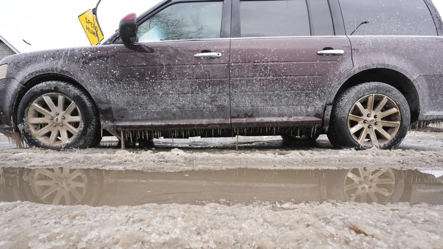 Sebuah truk pemuat depan melaju di Green Street setelah pipa air utama pecah di Detroit yang menyebabkan banjir besar dan memicu evakuasi, Senin, 17 Februari 2025. (Andy Morrison/Detroit News via AP)