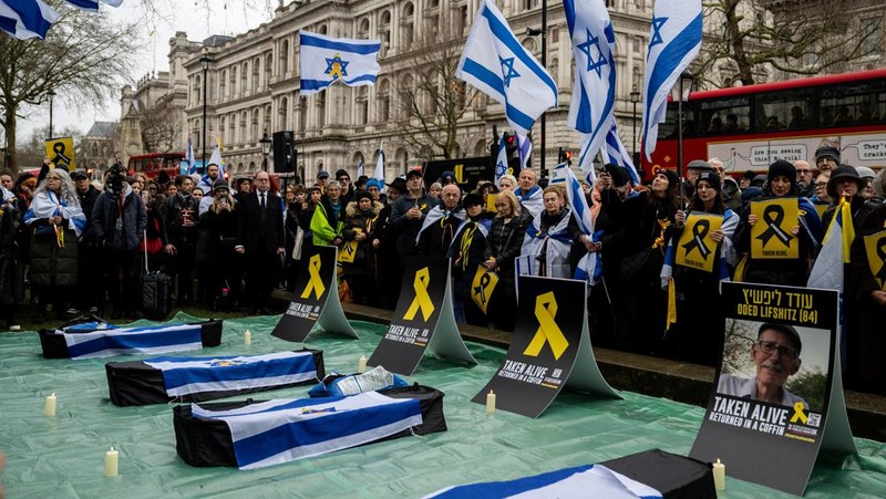 Warga Palestina menyaksikan penyerahan sandera yang telah meninggal, Oded Lifschitz, Shiri Bibas, dan kedua anaknya, Kfir dan Ariel Bibas, yang ditawan dalam serangan mematikan pada 7 Oktober 2023, oleh Hamas kepada Palang Merah sebagai bagian dari gencatan senjata dan kesepakatan pertukaran sandera-tahanan antara Hamas dan Israel, di Khan Younis di Jalur Gaza selatan, 20 Februari 2025. (REUTERS/Ramadan Abed)