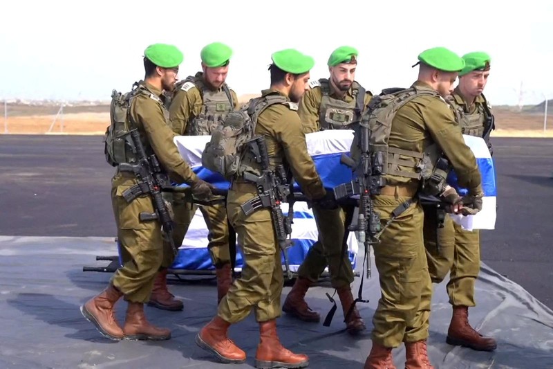 Warga Palestina menyaksikan penyerahan sandera yang telah meninggal, Oded Lifschitz, Shiri Bibas, dan kedua anaknya, Kfir dan Ariel Bibas, yang ditawan dalam serangan mematikan pada 7 Oktober 2023, oleh Hamas kepada Palang Merah sebagai bagian dari gencatan senjata dan kesepakatan pertukaran sandera-tahanan antara Hamas dan Israel, di Khan Younis di Jalur Gaza selatan, 20 Februari 2025. (REUTERS/Ramadan Abed)