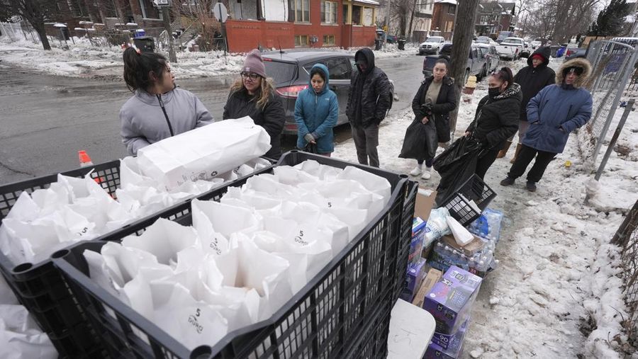 Sebuah truk pemuat depan melaju di Green Street setelah pipa air utama pecah di Detroit yang menyebabkan banjir besar dan memicu evakuasi, Senin, 17 Februari 2025. (Andy Morrison/Detroit News via AP)