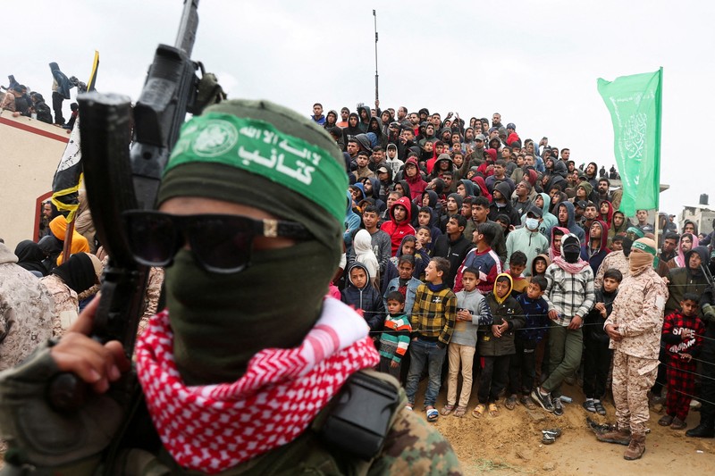 Warga Palestina menyaksikan penyerahan sandera yang telah meninggal, Oded Lifschitz, Shiri Bibas, dan kedua anaknya, Kfir dan Ariel Bibas, yang ditawan dalam serangan mematikan pada 7 Oktober 2023, oleh Hamas kepada Palang Merah sebagai bagian dari gencatan senjata dan kesepakatan pertukaran sandera-tahanan antara Hamas dan Israel, di Khan Younis di Jalur Gaza selatan, 20 Februari 2025. (REUTERS/Ramadan Abed) Warga Palestina menyaksikan penyerahan sandera yang telah meninggal, Oded Lifschitz, Shiri Bibas, dan kedua anaknya, Kfir dan Ariel Bibas, yang ditawan dalam serangan mematikan pada 7 Oktober 2023, oleh Hamas kepada Palang Merah sebagai bagian dari gencatan senjata dan kesepakatan pertukaran sandera-tahanan antara Hamas dan Israel, di Khan Younis di Jalur Gaza selatan, 20 Februari 2025. (REUTERS/Ramadan Abed)