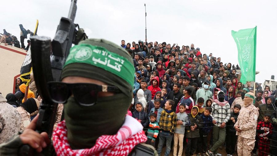 Warga Palestina menyaksikan penyerahan sandera yang telah meninggal, Oded Lifschitz, Shiri Bibas, dan kedua anaknya, Kfir dan Ariel Bibas, yang ditawan dalam serangan mematikan pada 7 Oktober 2023, oleh Hamas kepada Palang Merah sebagai bagian dari gencatan senjata dan kesepakatan pertukaran sandera-tahanan antara Hamas dan Israel, di Khan Younis di Jalur Gaza selatan, 20 Februari 2025. (REUTERS/Ramadan Abed)