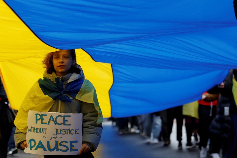 Orang-orang mengambil bagian dalam pawai untuk menandai ulang tahun ketiga invasi Rusia ke Ukraina, di pusat kota Lisbon, Portugal, 23 Februari 2025. (REUTERS/Pedro Nunes)