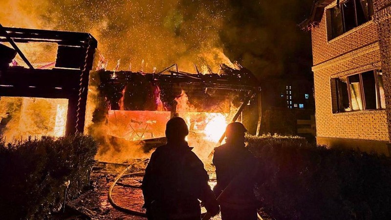 Petugas pemadam kebakaran bekerja di lokasi serangan pesawat nirawak Rusia di wilayah Kyiv, Ukraina, Rabu (26/2/2025). (Handout via REUTERS)