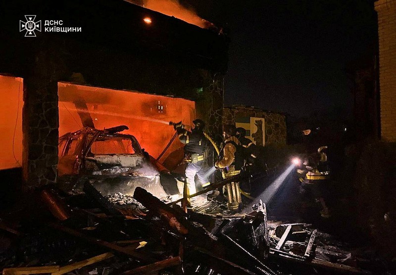 Petugas pemadam kebakaran bekerja di lokasi serangan pesawat nirawak Rusia di wilayah Kyiv, Ukraina, Rabu (26/2/2025). (Handout via REUTERS)