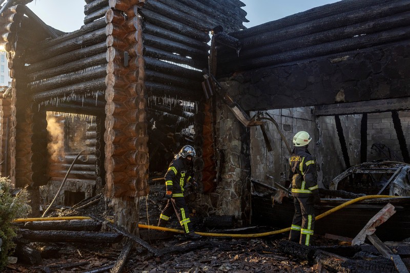 Petugas pemadam kebakaran bekerja di lokasi serangan pesawat nirawak Rusia di wilayah Kyiv, Ukraina, Rabu (26/2/2025). (Handout via REUTERS)