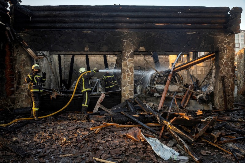Petugas pemadam kebakaran bekerja di lokasi serangan pesawat nirawak Rusia di wilayah Kyiv, Ukraina, Rabu (26/2/2025). (Handout via REUTERS)