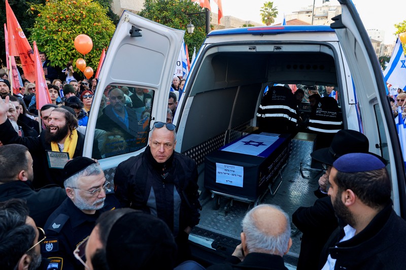 Warga Israel mengibarkan bendera Israel saat konvoi yang membawa peti jenazah Shiri, 32 tahun, dan kedua anaknya Kfir, 9 bulan, dan Ariel, 4 tahun, dari keluarga Bibas, yang diculik dari rumah mereka di Kibbutz Nir Oz selama serangan mematikan pada 7 Oktober 2023 oleh Hamas dan kemudian dibunuh di Gaza, berjalan sebagai bagian dari prosesi pemakaman mereka di Ashkelon, Israel, 26 Februari 2025. Warga Israel mengibarkan bendera Israel saat konvoi yang membawa peti jenazah Shiri, 32 tahun, dan kedua anaknya Kfir, 9 bulan, dan Ariel, 4 tahun, dari keluarga Bibas, yang diculik dari rumah mereka di Kibbutz Nir Oz selama serangan mematikan pada 7 Oktober 2023 oleh Hamas dan kemudian dibunuh di Gaza, berjalan sebagai bagian dari prosesi pemakaman mereka di Ashkelon, Israel, 26 Februari 2025. (REUTERS/Amir Cohen)