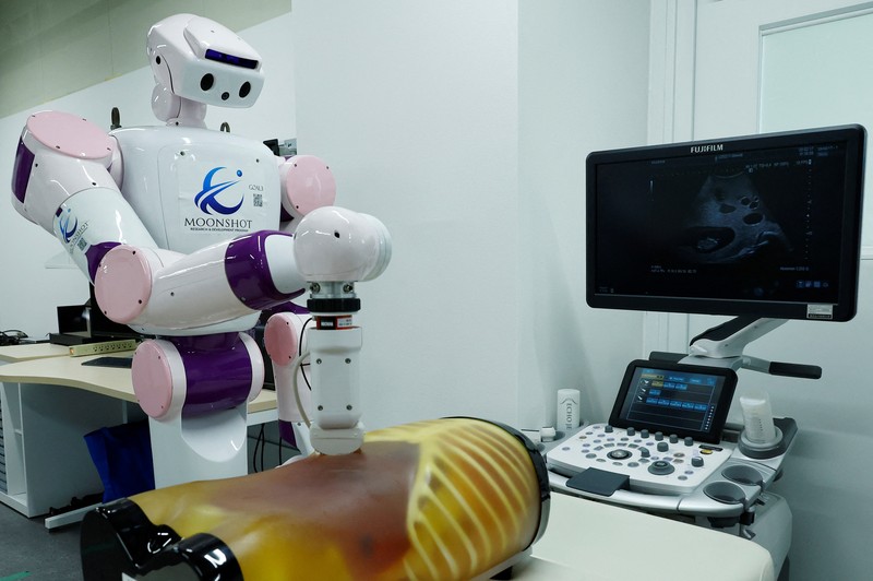 AIREC, robot humanoid yang digerakkan oleh kecerdasan buatan (AI), mendemonstrasikan manuver untuk mengganti popok atau mencegah luka baring dengan seorang peneliti di laboratorium Universitas Waseda di Tokyo, Jepang. (REUTERS/Kim Kyung-Hoon) AIREC, robot humanoid yang digerakkan oleh kecerdasan buatan (AI), mendemonstrasikan manuver untuk mengganti popok atau mencegah luka baring dengan seorang peneliti di laboratorium Universitas Waseda di Tokyo, Jepang. (REUTERS/Kim Kyung-Hoon)