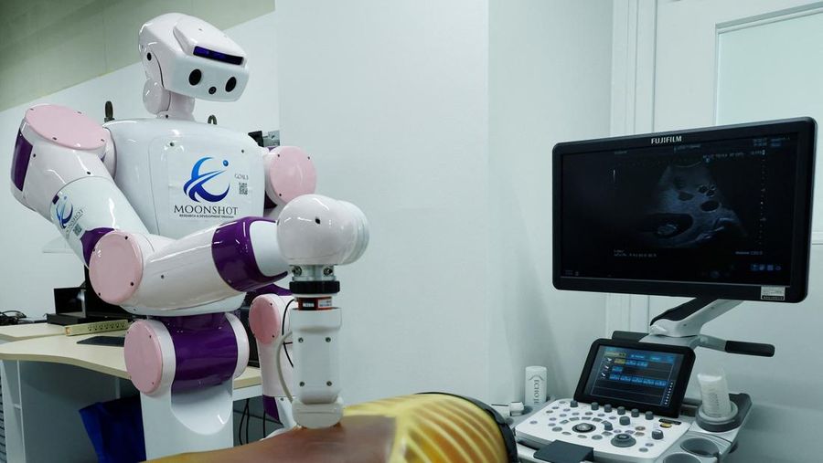 AIREC, robot humanoid nan digerakkan oleh kepintaran buatan (AI), mendemonstrasikan manuver untuk mengganti popok alias mencegah luka baring dengan seorang peneliti di laboratorium Universitas Waseda di Tokyo, Jepang. (REUTERS/Kim Kyung-Hoon)