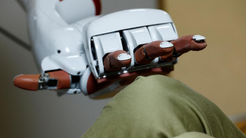 AIREC, robot humanoid yang digerakkan oleh kecerdasan buatan (AI), mendemonstrasikan manuver untuk mengganti popok atau mencegah luka baring dengan seorang peneliti di laboratorium Universitas Waseda di Tokyo, Jepang. (REUTERS/Kim Kyung-Hoon)