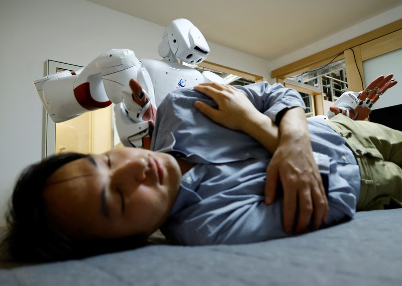AIREC, robot humanoid yang digerakkan oleh kecerdasan buatan (AI), mendemonstrasikan manuver untuk mengganti popok atau mencegah luka baring dengan seorang peneliti di laboratorium Universitas Waseda di Tokyo, Jepang. (REUTERS/Kim Kyung-Hoon) AIREC, robot humanoid yang digerakkan oleh kecerdasan buatan (AI), mendemonstrasikan manuver untuk mengganti popok atau mencegah luka baring dengan seorang peneliti di laboratorium Universitas Waseda di Tokyo, Jepang. (REUTERS/Kim Kyung-Hoon)