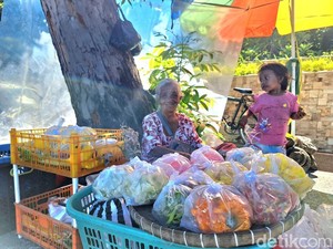 Senyum Lebar Penjual Bunga Ziarah Makam di Mataram