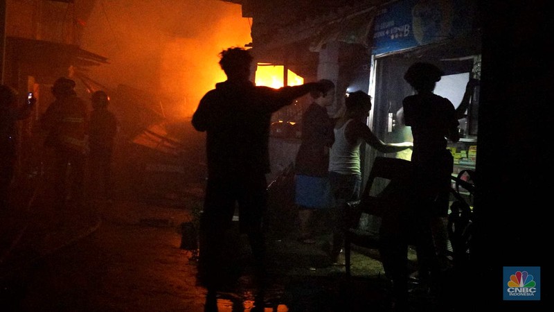 Petugas pemadam saat memadamkan api saat kebakaran melanda rumah tinggal di kawasan Duren Sawit, Jakarta Timur, Jumat (28/2/2025). (CNBC Indonesia/Muhammad Sabki)