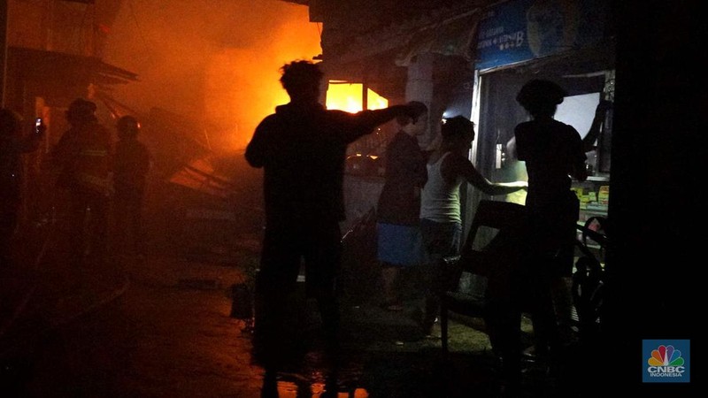 Petugas pemadam saat memadamkan api saat kebakaran melanda rumah tinggal di kawasan Duren Sawit, Jakarta Timur, Jumat (28/2/2025). (CNBC Indonesia/Muhammad Sabki)