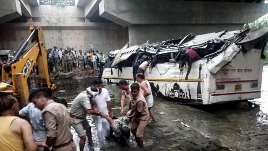  Graphic content / Onlookers and Indian police retrieve dead bodies from the crumpled remains of a bus that crashed on the Delhi-Agra expressway, near Agra on July 8, 2019. A bus careered off one of India's busiest roads early July 8 killing at least 29 people, police said. (Photo by AFP) / GRAPHIC CONTENT