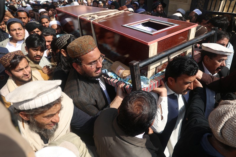 Orang-orang membawa peti jenazah saat pemakaman korban yang meninggal dalam serangan bom bunuh diri pada hari salat Jumat di sebuah pesantren di Akora Khattak, di Peshawar, Pakistan, 1 Maret 2025. (AP Photo/Muhammad Sajjad)