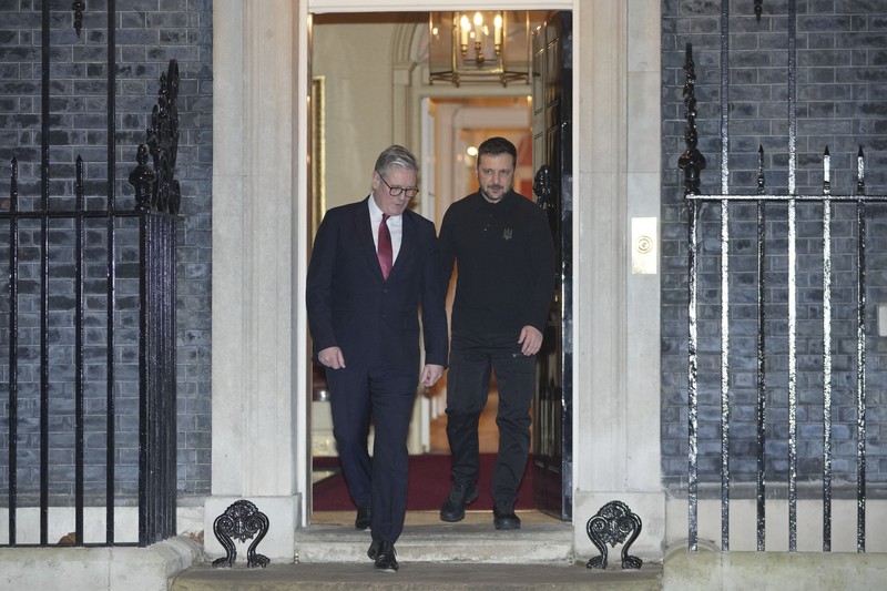 Perdana Menteri Inggris Keir Starmer menyambut Presiden Volodymyr Zelensky dengan pelukan hangat pada hari Sabtu (1/3/2025). (AP Photo/Kin Cheung)