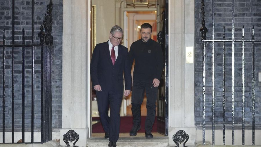 Perdana Menteri Inggris Keir Starmer menyambut Presiden Volodymyr Zelensky dengan pelukan hangat pada hari Sabtu (1/3/2025). (AP Photo/Kin Cheung)