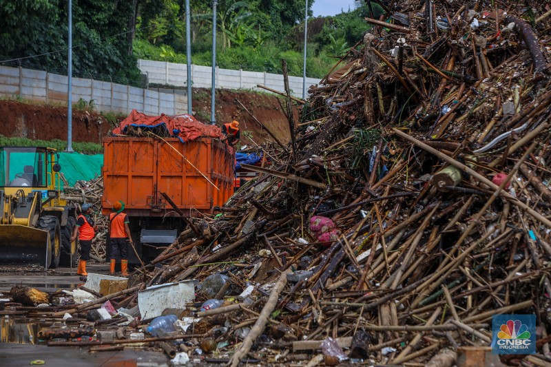 Petugas Dinas Lingkungan Hidup DKI Jakarta menggunakan alat berat saat membersihkan sampah di Saringan Sampah TB Simatupang (SSTBS), Jakarta, Senin (3/3/2025). (CNBC Indonesia/Faisal Rahman)
