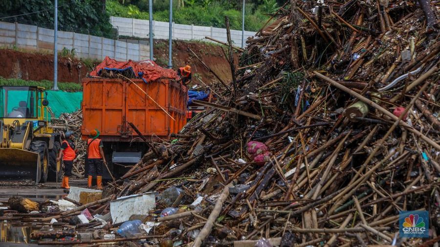 Petugas Dinas Lingkungan Hidup DKI Jakarta menggunakan alat berat saat membersihkan sampah di Saringan Sampah TB Simatupang (SSTBS), Jakarta, Senin (3/3/2025). (CNBC Indonesia/Faisal Rahman)