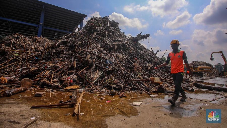 Petugas Dinas Lingkungan Hidup DKI Jakarta menggunakan alat berat saat membersihkan sampah di Saringan Sampah TB Simatupang (SSTBS), Jakarta, Senin (3/3/2025). (CNBC Indonesia/Faisal Rahman)