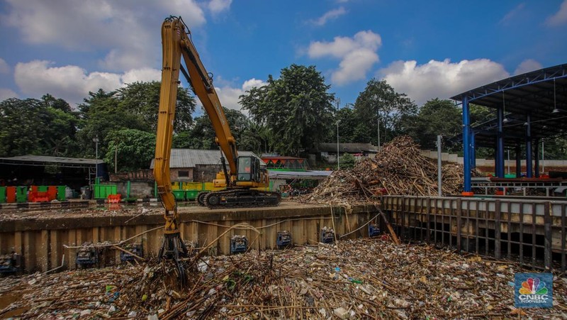 Petugas Dinas Lingkungan Hidup DKI Jakarta menggunakan alat berat saat membersihkan sampah di Saringan Sampah TB Simatupang (SSTBS), Jakarta, Senin (3/3/2025). (CNBC Indonesia/Faisal Rahman)