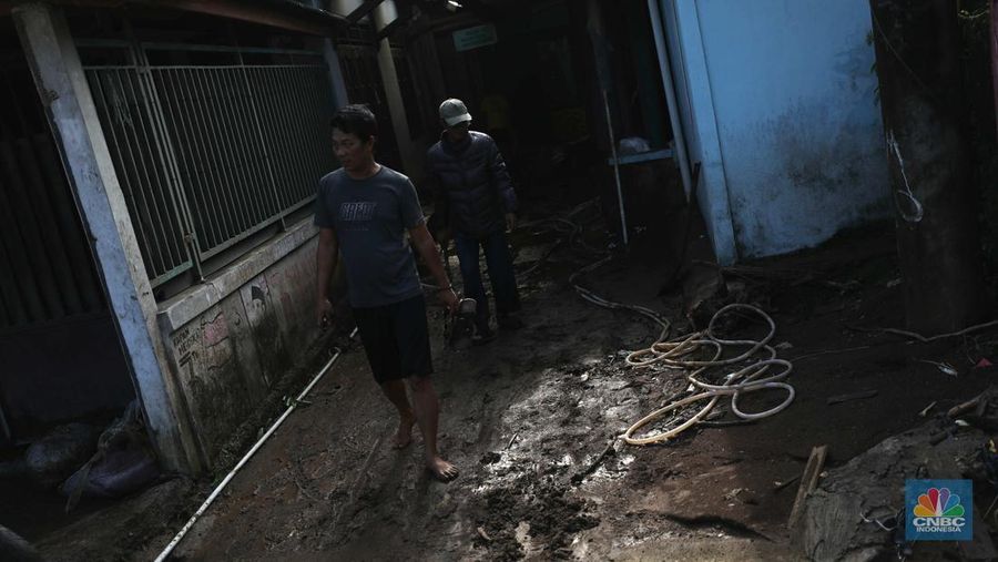 Seorang warga membersihkan rumah dari sisa-sisa banjir bandang di Desa Citeko, Kecamatan Cisarua, Jawa Barat, Senin (3/3/2025). (CNBC Indonesia/Tri Susilo)