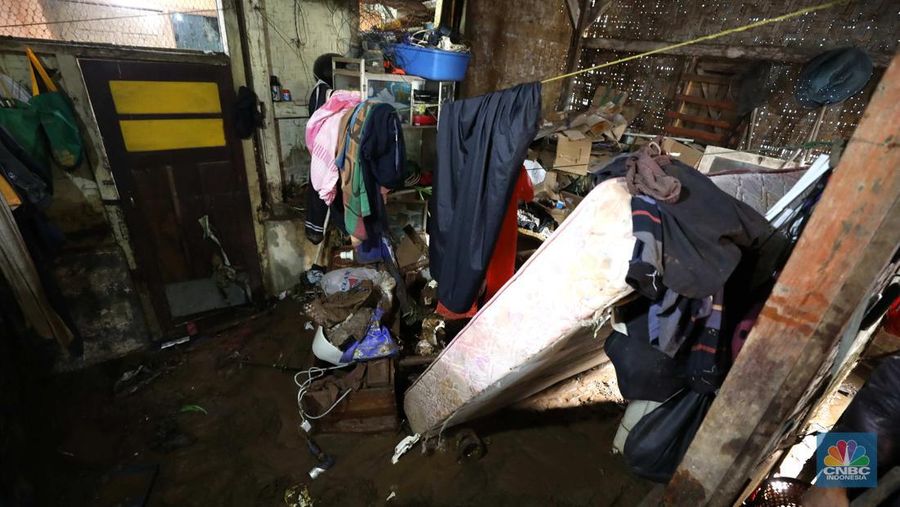 Seorang warga membersihkan rumah dari sisa-sisa banjir bandang di Desa Citeko, Kecamatan Cisarua, Jawa Barat, Senin (3/3/2025). (CNBC Indonesia/Tri Susilo)