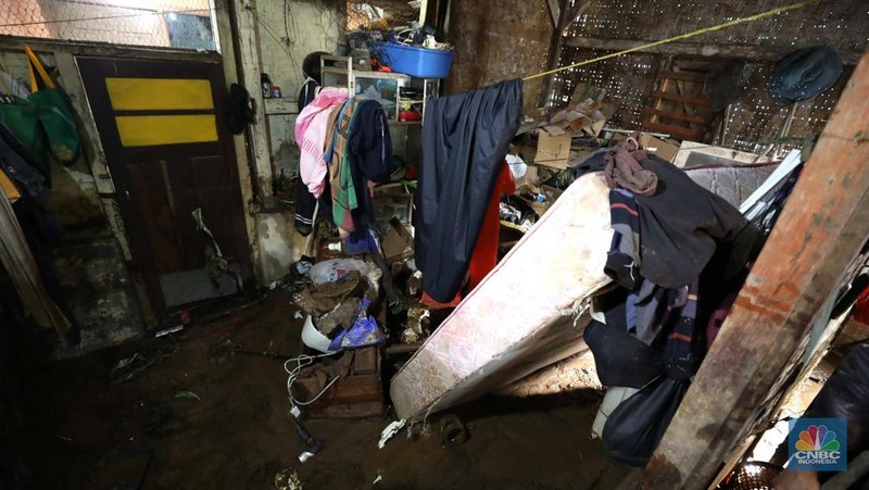 Seorang warga membersihkan rumah dari sisa-sisa banjir bandang di Desa Citeko, Kecamatan Cisarua, Jawa Barat, Senin (3/3/2025). (CNBC Indonesia/Tri Susilo)
