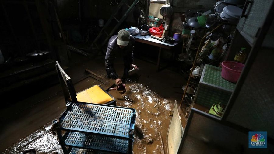 Seorang warga membersihkan rumah dari sisa-sisa banjir bandang di Desa Citeko, Kecamatan Cisarua, Jawa Barat, Senin (3/3/2025). (CNBC Indonesia/Tri Susilo)