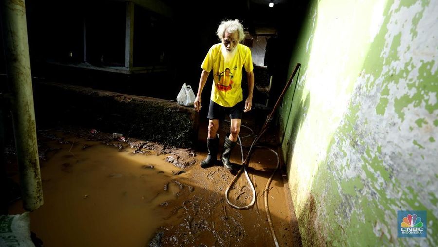 Seorang warga membersihkan rumah dari sisa-sisa banjir bandang di Desa Citeko, Kecamatan Cisarua, Jawa Barat, Senin (3/3/2025). (CNBC Indonesia/Tri Susilo)