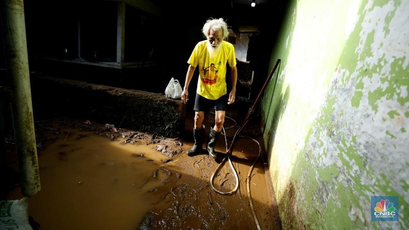 Seorang warga membersihkan rumah dari sisa-sisa banjir bandang di Desa Citeko, Kecamatan Cisarua, Jawa Barat, Senin (3/3/2025). (CNBC Indonesia/Tri Susilo)