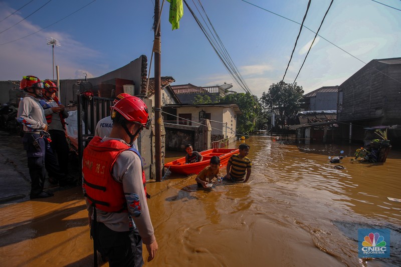 Warga beraktivitas saat banjir melanda kawasan Pejaten Timur, Pasar Minggu di Jakarta, Senin (3/3/2025). (CNBC Indonesia/Faisal Rahman)