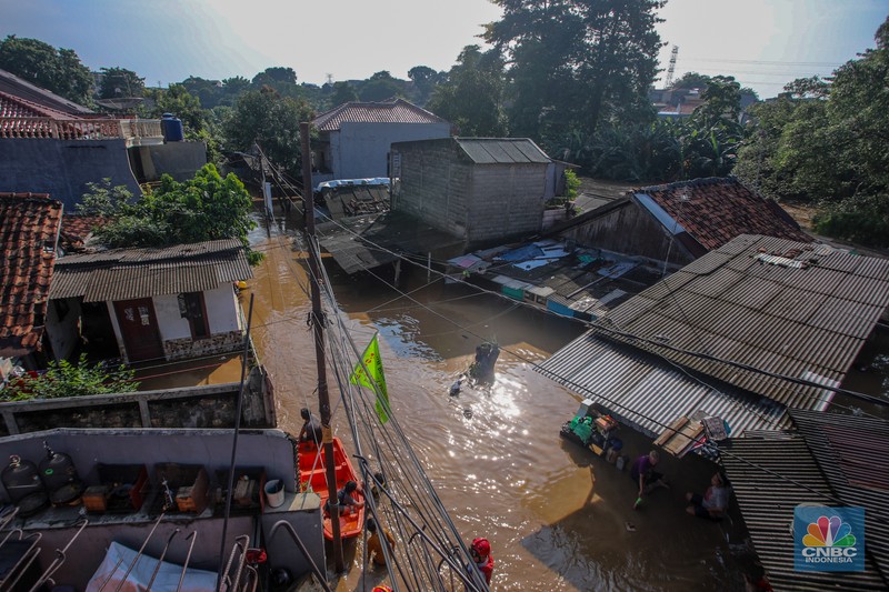 Warga beraktivitas saat banjir melanda kawasan Pejaten Timur, Pasar Minggu di Jakarta, Senin (3/3/2025). (CNBC Indonesia/Faisal Rahman)