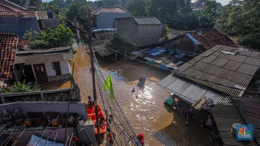 Warga beraktivitas saat banjir melanda kawasan Pejaten Timur, Pasar Minggu di Jakarta, Senin (3/3/2025). (CNBC Indonesia/Faisal Rahman)