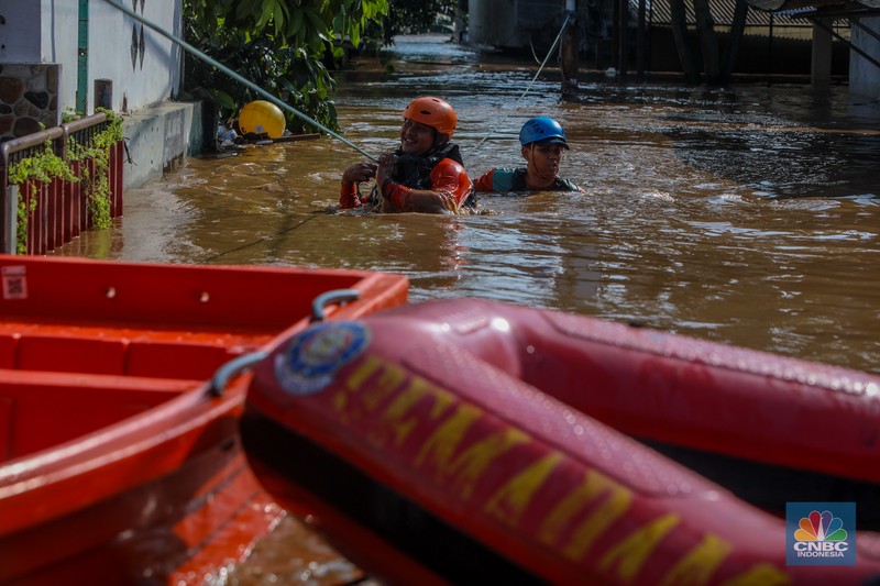 Warga beraktivitas saat banjir melanda kawasan Pejaten Timur, Pasar Minggu di Jakarta, Senin (3/3/2025). (CNBC Indonesia/Faisal Rahman)