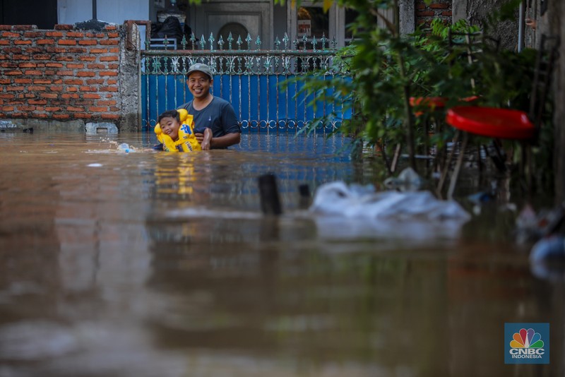 Warga beraktivitas saat banjir melanda kawasan Pejaten Timur, Pasar Minggu di Jakarta, Senin (3/3/2025). (CNBC Indonesia/Faisal Rahman)