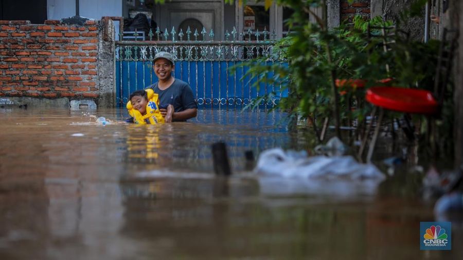 Warga beraktivitas saat banjir melanda kawasan Pejaten Timur, Pasar Minggu di Jakarta, Senin (3/3/2025). (CNBC Indonesia/Faisal Rahman)