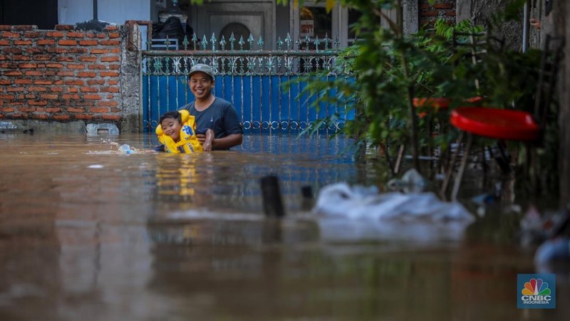 Warga beraktivitas saat banjir melanda kawasan Pejaten Timur, Pasar Minggu di Jakarta, Senin (3/3/2025). (CNBC Indonesia/Faisal Rahman)