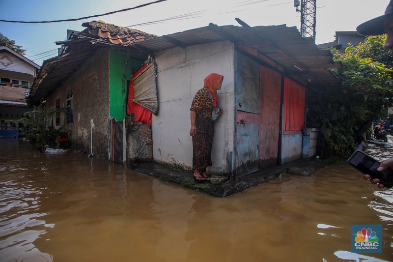 Warga beraktivitas saat banjir melanda kawasan Pejaten Timur, Pasar Minggu di Jakarta, Senin (3/3/2025). (CNBC Indonesia/Faisal Rahman)