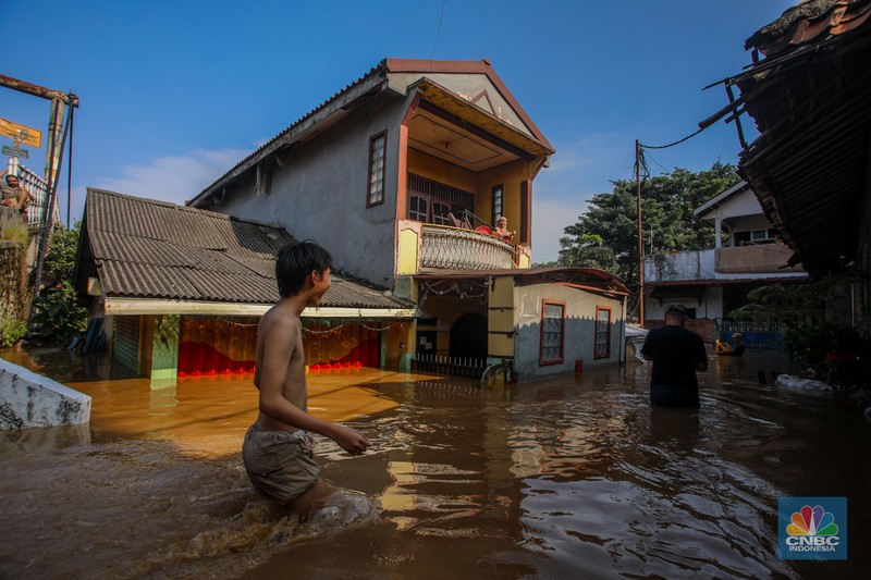 Warga beraktivitas saat banjir melanda kawasan Pejaten Timur, Pasar Minggu di Jakarta, Senin (3/3/2025). (CNBC Indonesia/Faisal Rahman)