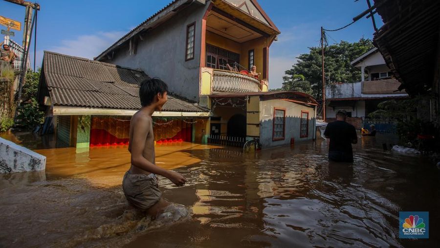 Warga beraktivitas saat banjir melanda kawasan Pejaten Timur, Pasar Minggu di Jakarta, Senin (3/3/2025). (CNBC Indonesia/Faisal Rahman)