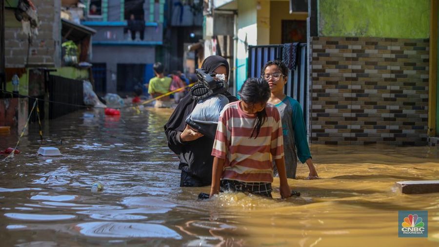 Warga beraktivitas saat banjir melanda kawasan Pejaten Timur, Pasar Minggu di Jakarta, Senin (3/3/2025). (CNBC Indonesia/Faisal Rahman)