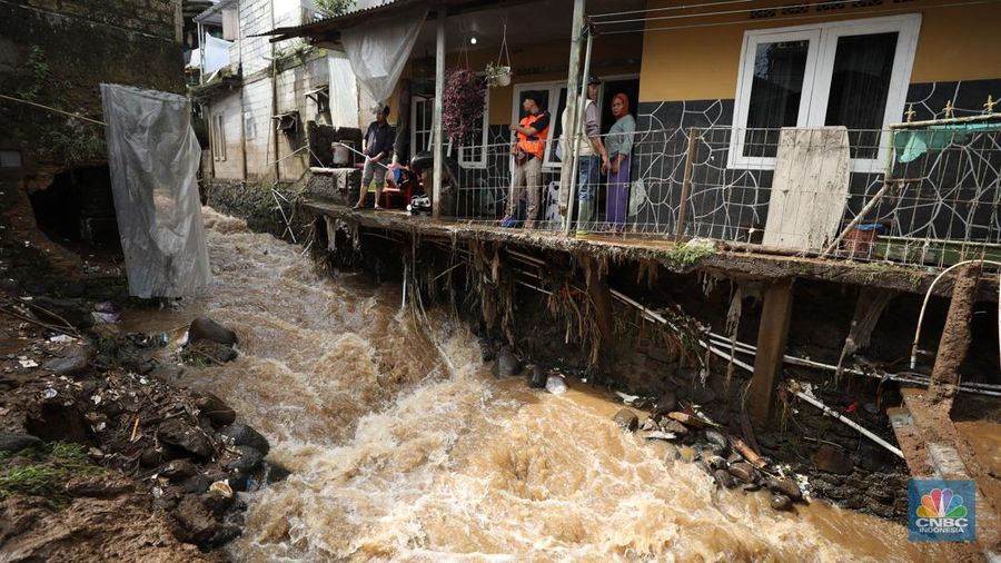 Warga membersihkan sisa-sisa lumpur dan sampah banjir yang melanda Kampung Pensiunan, Desa Tugu Selatan, Kecamatan Cisarua, Kabupaten Bogor, Jawa Barat, Senin (3/3/2025). (վ/Tri Susilo)